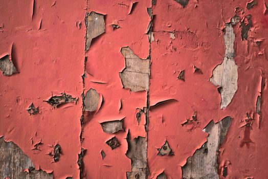 Texture of peeling red paint on grungy old wood