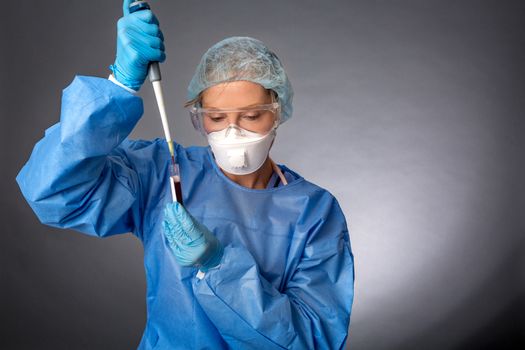 Medical laboratory worker using a pipette to sample blood test for health analysis or research