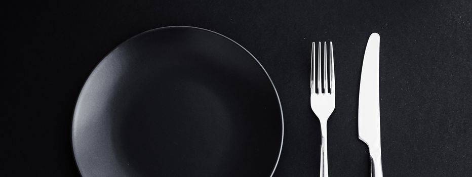 Empty plates and silverware on black background, premium tableware for holiday dinner, minimalistic design and diet concept