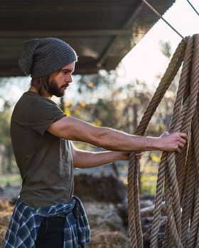 Portrait of young bearded man taking the rope with beautiful sunlight