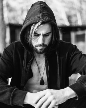 Portrait of young bearded man with beautiful sunlight, he is hooded