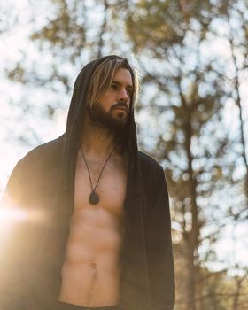 Portrait of young bearded man with beautiful sunlight, he is hooded