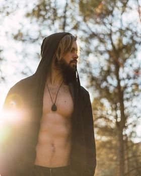 Portrait of young bearded man with beautiful sunlight, he is hooded