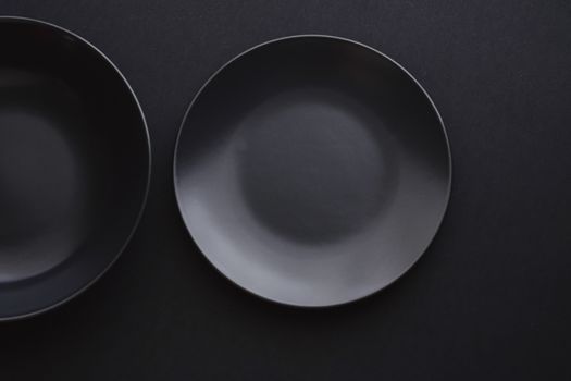 Empty plates on black background, premium dishware for holiday dinner, minimalistic design and diet concept