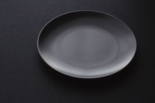 Empty plates on black background, premium dishware for holiday dinner, minimalistic design and diet concept