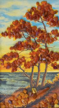 Autumn tree with yellow leaves on the seashore, picture from amber.