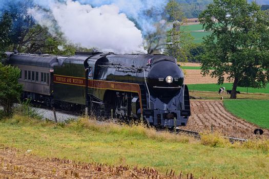Lancaster, Pennsylvania, September 2019 - Norfolk and Western Steam Locomotive no. 611 Blowing Smoke and Steam as it Travel Through Countryside