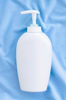 Blank label bottle of antibacterial liquid soap and hand sanitizer mockup on blue silk, hygiene product and health care, flatlay