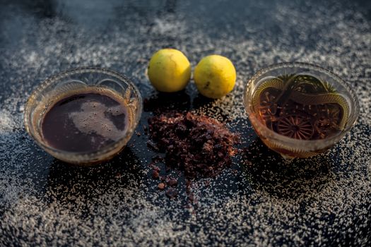 All-purpose ayurvedic salt face mask on the black wooden surface consisting of salt, rock salt, lemon juice, and honey. The face mask as well as a face pack. Horizontal top shot.