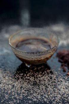 Close up shot of a bowl of the salt face mask of rock salt or sendha namak in it along with some crystals spread on the surface. Vertical shot.