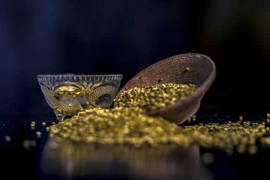 Close shot of mung bean or moong dal in a clay bowl along with some water and moong dal well mixed on a black glossy surface. Horizontal shot with Rembrandt lighting technique.