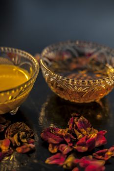 Ayurvedic moisturizer face mask on black glossy surface in a glass bowl with some ghee or clarified butter, honey and pack.