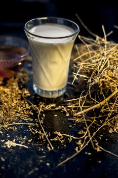 shankhpushpi or Convolvulus pluricaulis roots along with some milk and honey on the wooden surface making a memory booster tonic. Vertical shot.