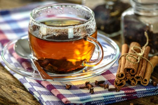 Natural and aromatic cup of tea with cinnamon and cloves in vintage style