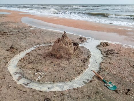 Sand castle on the beach with shells. Children's games at sea.