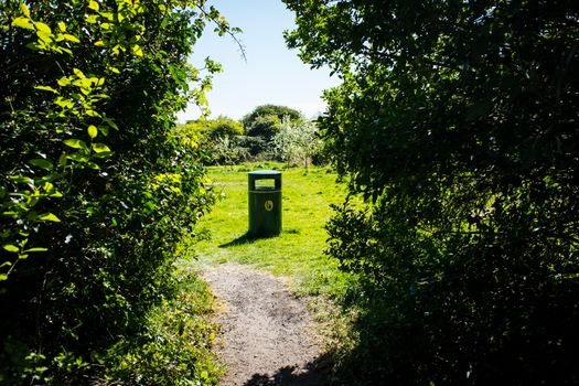 Bin in park by footpath on leaving woodland walk