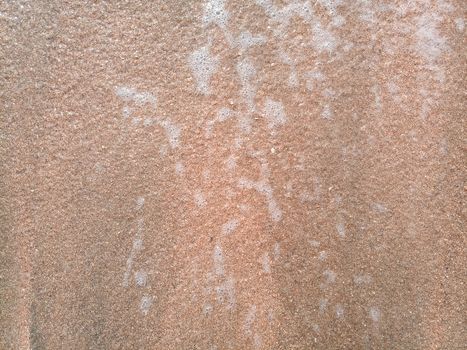 The Mor wave on the coastal sand, the background texture of the sea wave and foam on the sand.