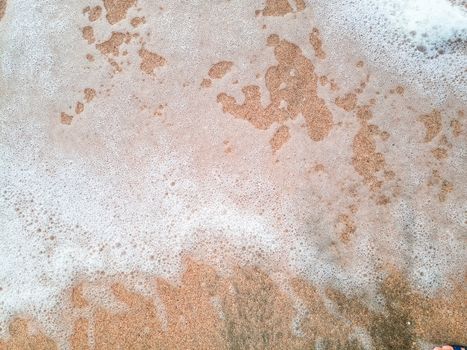 The Mor wave on the coastal sand, the background texture of the sea wave and foam on the sand.