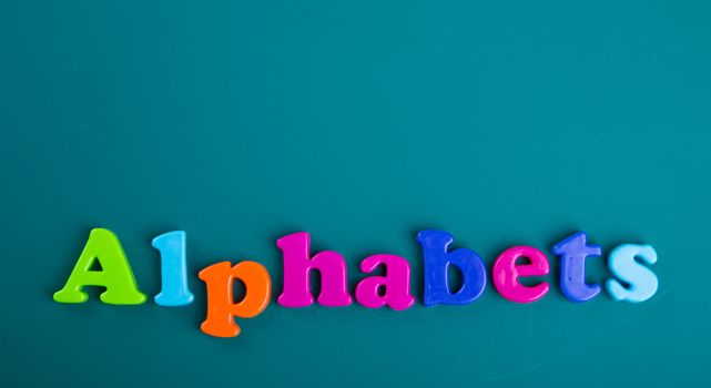 Colorful Alphabet magnetic letters on green background