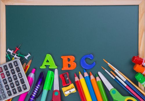 School supplies on blackboard background ready for your design