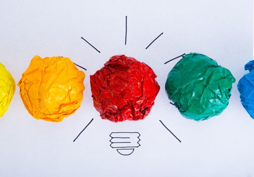 Inspiration concept crumpled color paper light bulb metaphor for good idea.