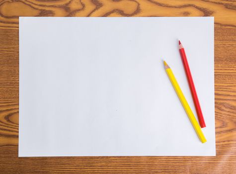 Blank white paper and color pencil on wooden table
