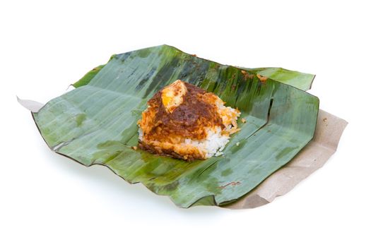 nasi lemak, a traditional malay curry paste rice dish served on a banana leaf