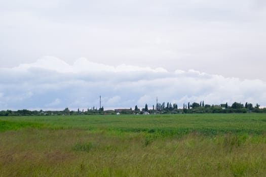 Cloudy landscape, the village before the rain, visible large cumulus clouds and clouds over the village.