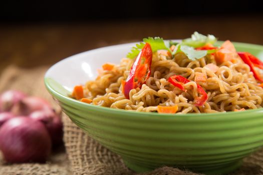 A Bowl of instant noodles on wooden table