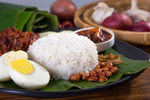 nasi lemak, a traditional malay curry paste rice dish served on a banana leaf