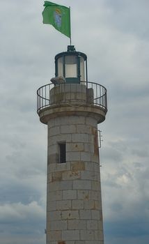 Stone lighthouse with green brittany flag at Cancale, France