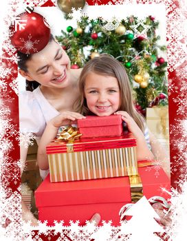 Mother and daughter at home holding a Christmas gift against christmas themed frame