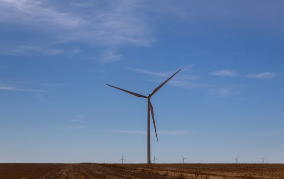 A windmill with modern wind turbines in the located in West Texas sunny day