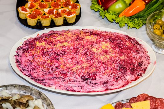 Herring salad under a fur coat. Different dishes on the table