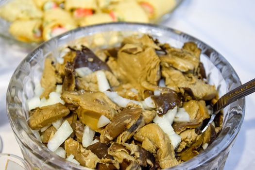 Marinated mushrooms with onions in a crystal cup.