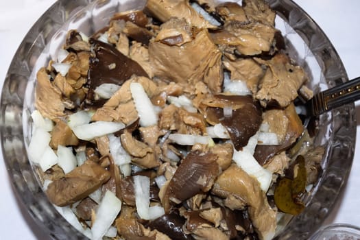 Marinated mushrooms with onions in a crystal cup.