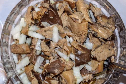 Marinated mushrooms with onions in a crystal cup.