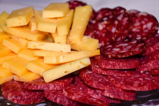 Sausage and cheese on a plate. table setting with sausages and cheeses.