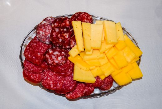 Sausage and cheese on a plate. table setting with sausages and cheeses.