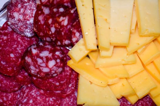 Sausage and cheese on a plate. table setting with sausages and cheeses.