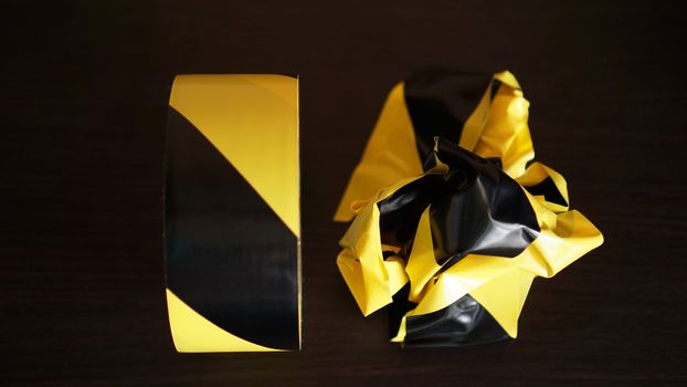Crumpled yellow and black tapes on dark background