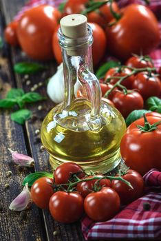 Classic ingredients of Italian cuisine: basil, garlic, olive oil, pepper on a wooden vintage table (reduced tone)