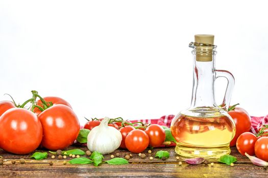 Classic ingredients of Italian cuisine: basil, garlic, olive oil, pepper on a wooden vintage table.