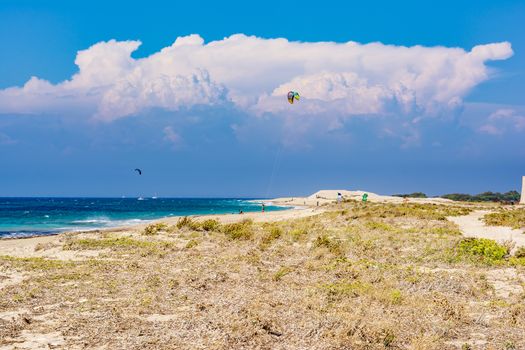 Agios Ioannis beach in Lefkas island Greece. Colorful power kites span across the sky from kite-surfers.