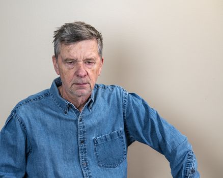 Head and shoulders portrait of a senior caucasian man unshaven and facing camera