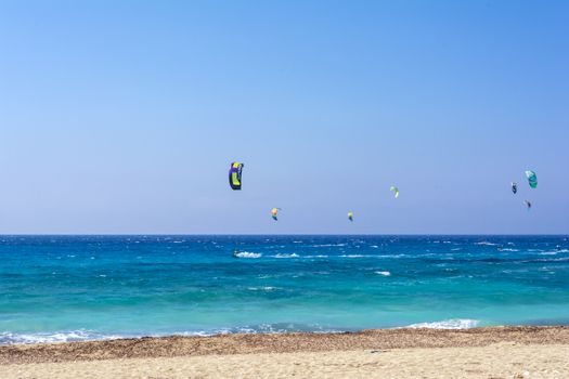 Agios Ioannis beach in Lefkas island Greece. Colorful power kites span across the sky from kite-surfers.