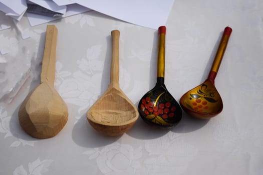 Wooden painted spoons on a white table. National Russian art.