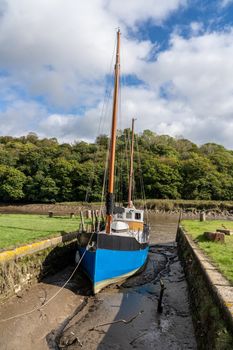 Blue fishing boat in small quay off the tidal River Tamar at Cotehele in Devon