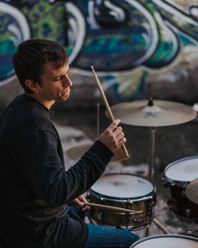 Young man playing drums in an underground environment