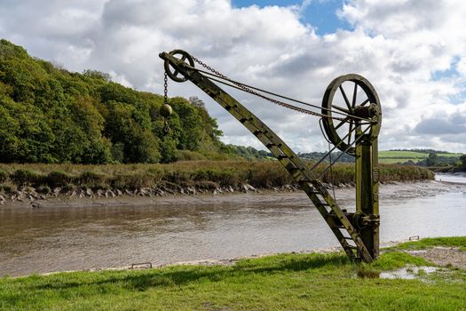 Rusty old metal winch or crane for cargo by the tidal River Tamar at Cotehele in Devon